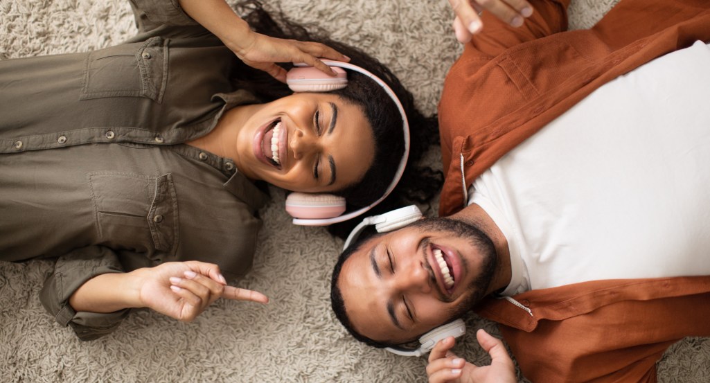 Two people laying on the ground wearing headphones